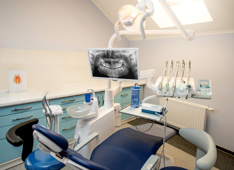 A dental office featuring a dental chair and a computer, highlighting a clean and organized treatment area.