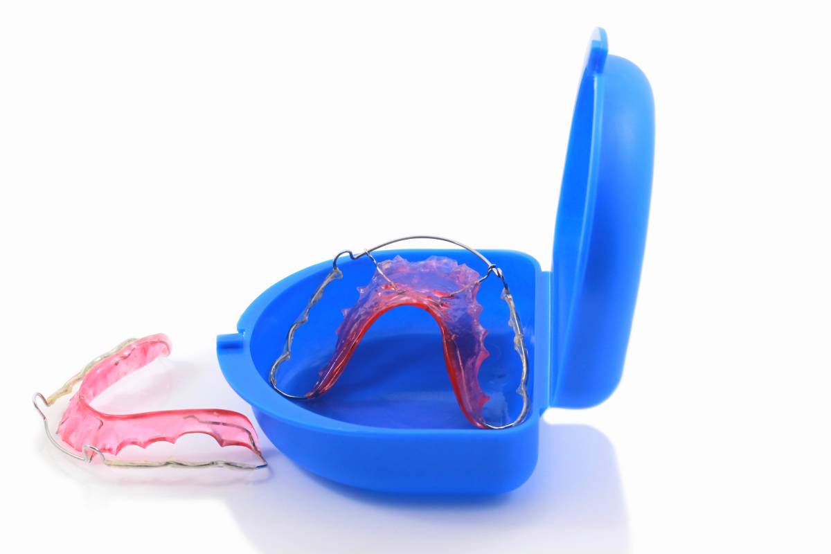 Acrylic dental retainer isolated on white in box